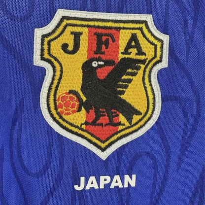 Embroidered logo with 'JFA' and a black bird on a yellow shield against a blue background