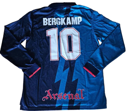 Blue Arsenal football jersey with 'Bergkamp' and number '10' on a wooden surface